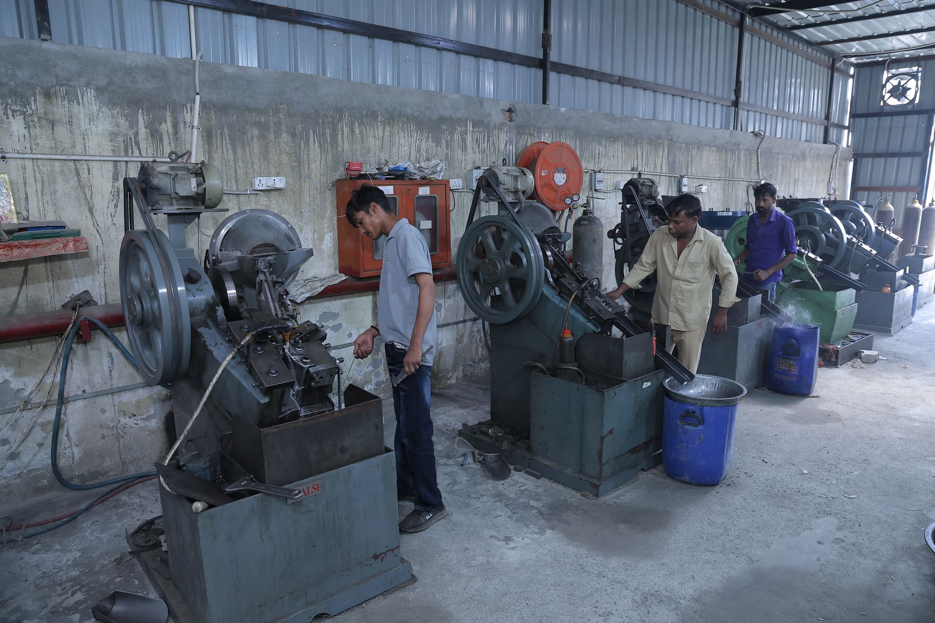 Workers on the Aggarwal Industries factory floor operating screw manufacturing machines