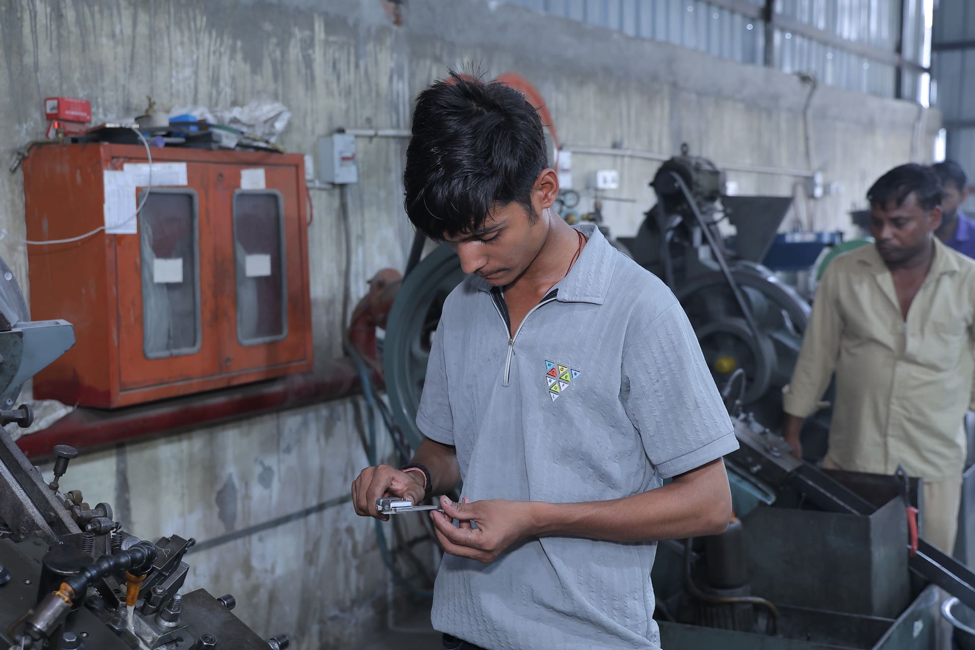 Quality inspector measuring a fastener component with a precision caliper