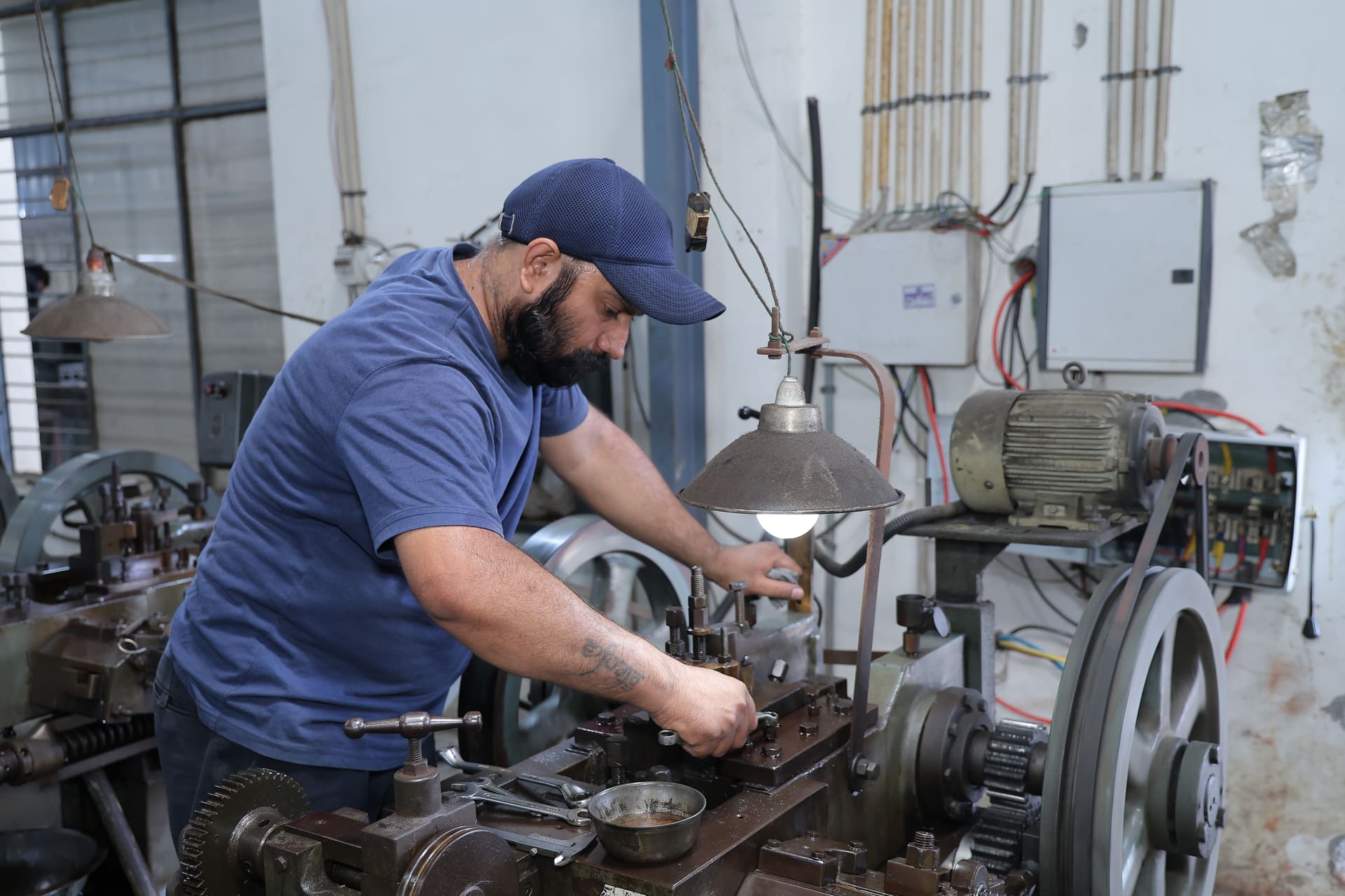 Worker operating a thread rolling machine at the Aggarwal Industries production floor